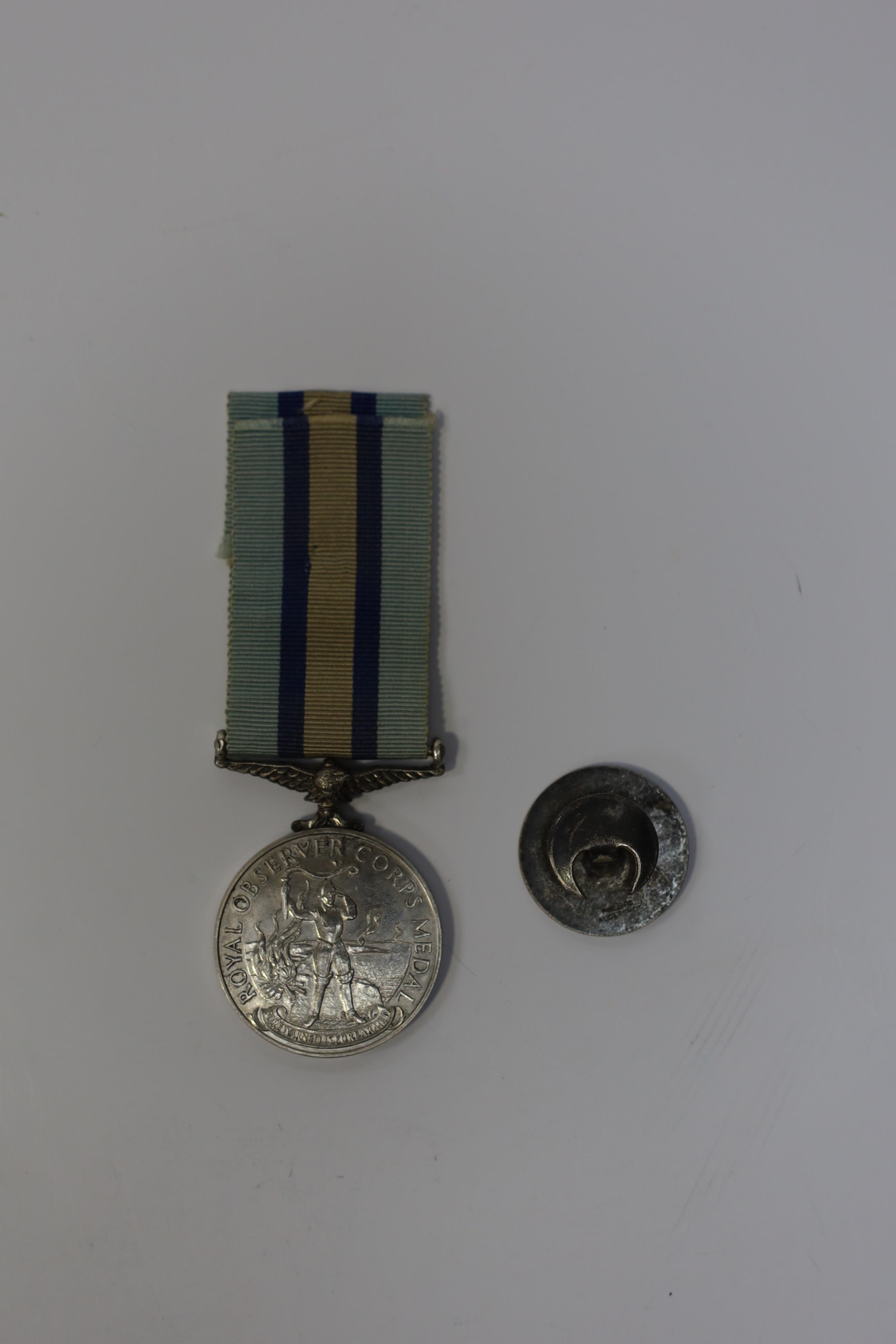 An ERII (B) Royal Observer Corps medal to Observer W.Cook with a lapel badge. Condition - fair.